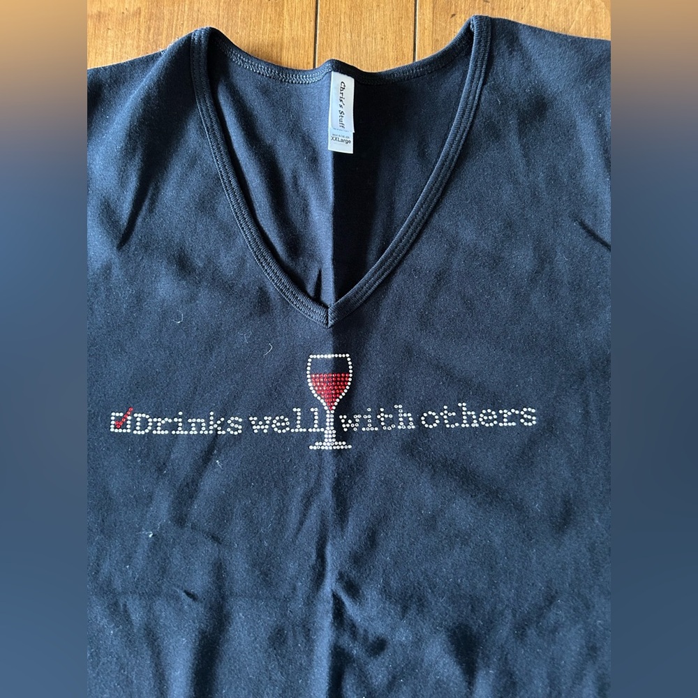 Women’s black v neck tee “drinks well with others”